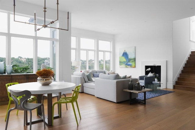 living room featuring hardwood / wood-style flooring, a notable chandelier, and a towering ceiling