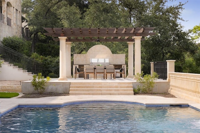 view of pool with a pergola, a patio area, grilling area, and exterior fireplace