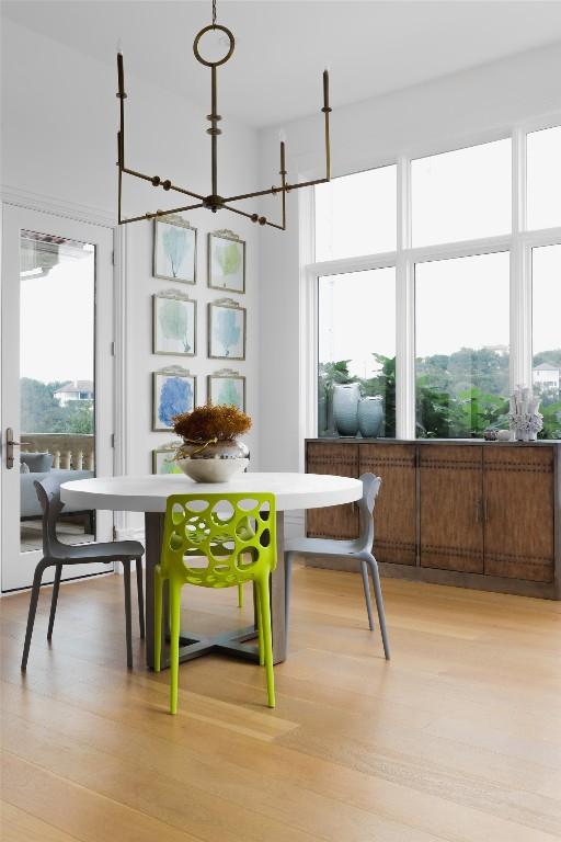 dining area featuring light wood-type flooring and a notable chandelier