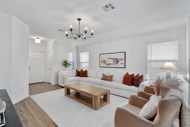 living room featuring a chandelier and light hardwood / wood-style floors