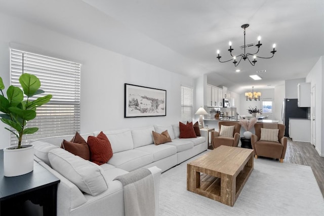 living room featuring light hardwood / wood-style flooring and a notable chandelier