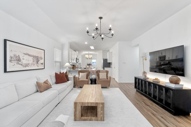 living room with a chandelier and light hardwood / wood-style floors