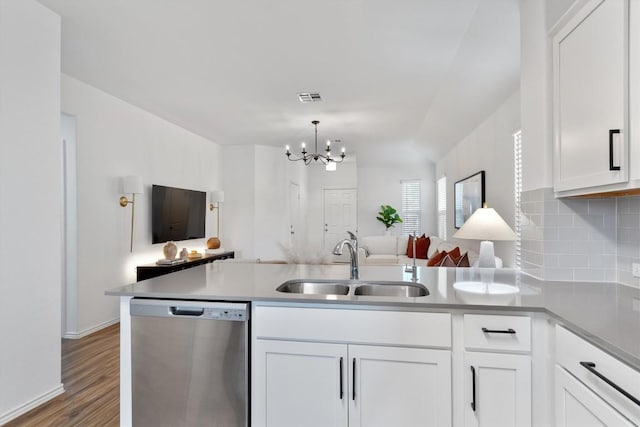 kitchen with kitchen peninsula, dishwasher, white cabinets, and sink