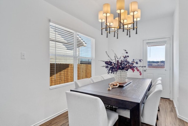 dining area with a wealth of natural light, hardwood / wood-style floors, and a chandelier