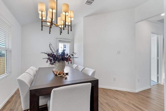 dining room with hardwood / wood-style flooring and a notable chandelier