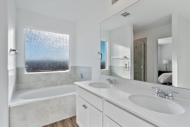 bathroom featuring hardwood / wood-style floors, vanity, and independent shower and bath