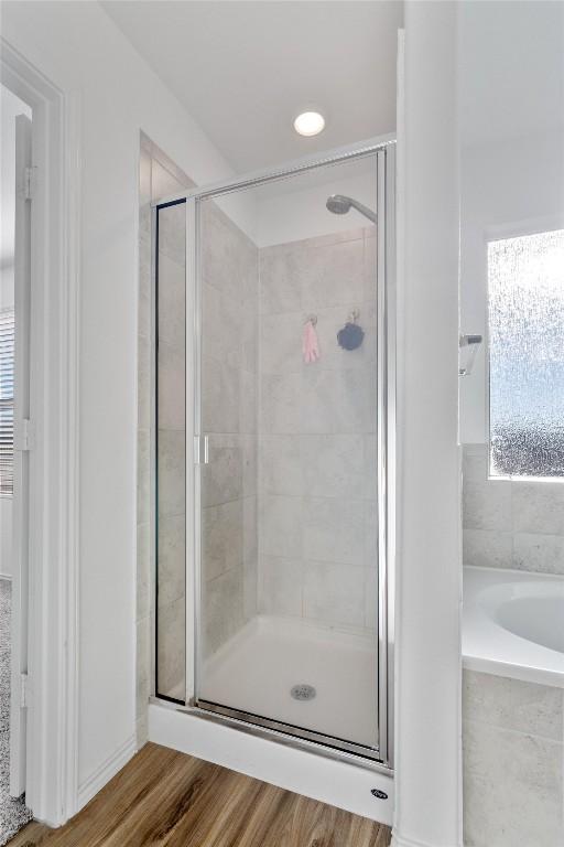 bathroom featuring independent shower and bath and hardwood / wood-style flooring