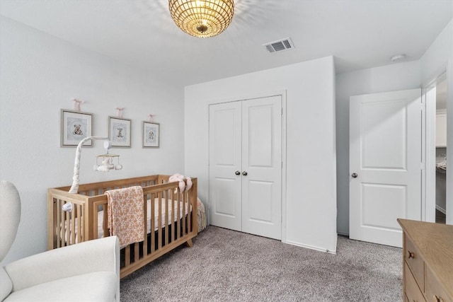 carpeted bedroom featuring a closet and a nursery area