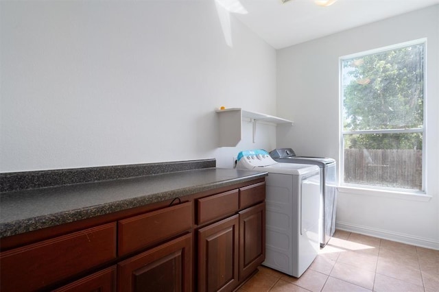 laundry room with washing machine and dryer, light tile patterned floors, and a healthy amount of sunlight