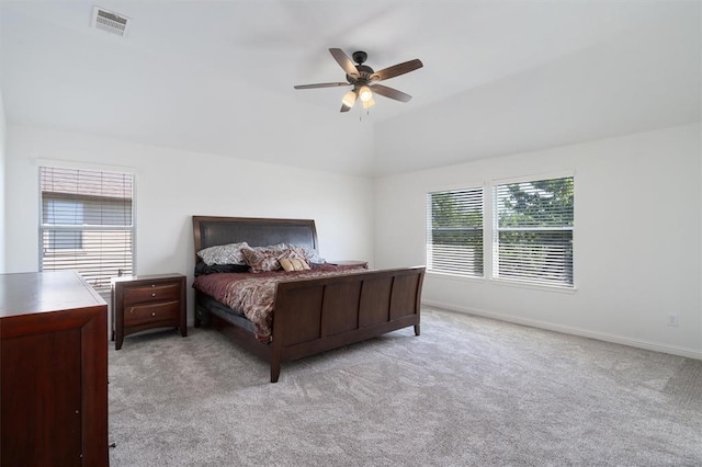 bedroom with multiple windows, light carpet, vaulted ceiling, and ceiling fan