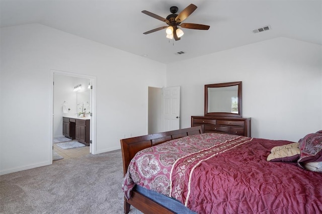 bedroom with ceiling fan, light colored carpet, connected bathroom, and vaulted ceiling