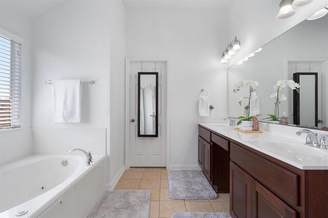 bathroom featuring tile patterned floors, a tub, a wealth of natural light, and vanity