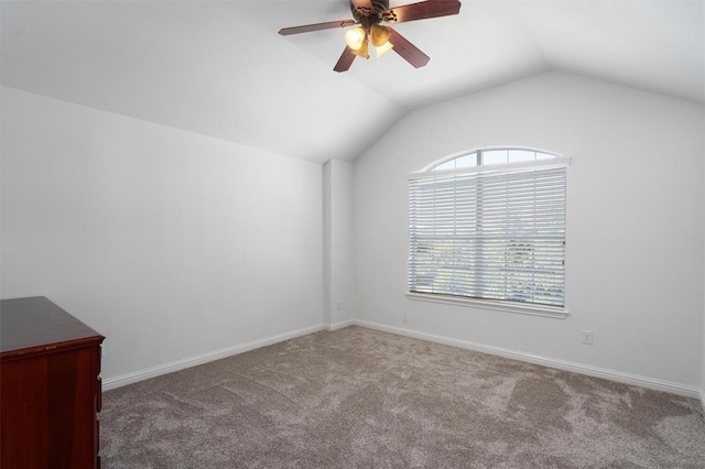 spare room featuring carpet, ceiling fan, and lofted ceiling