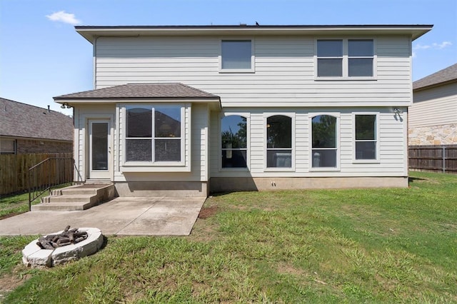 rear view of house with a yard, a patio, and a fire pit