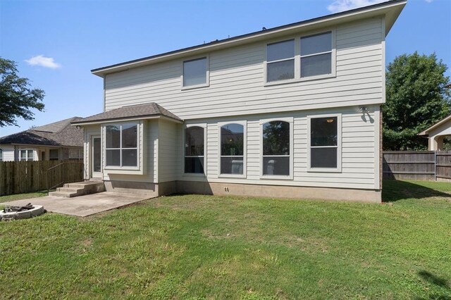 back of house with a lawn and a patio