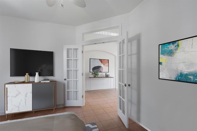 living room featuring ceiling fan, light tile patterned floors, and french doors