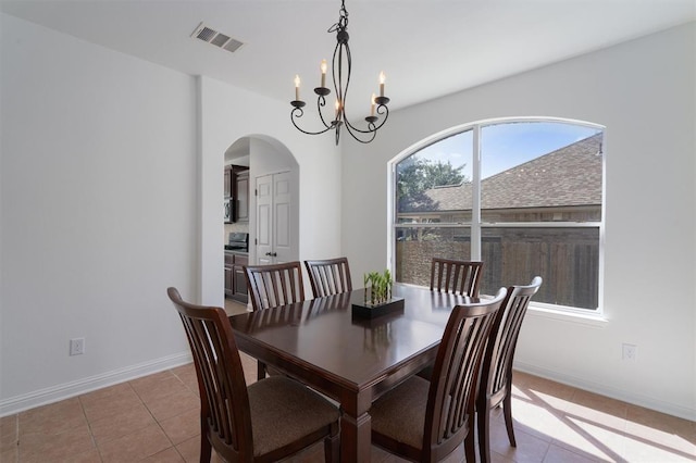 dining area with light tile patterned floors and a notable chandelier