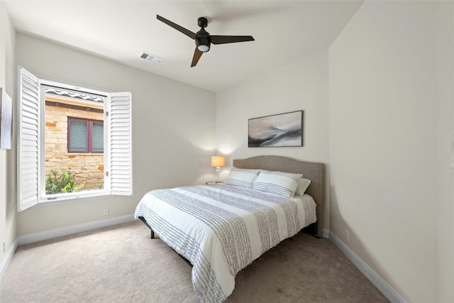 carpeted bedroom with a ceiling fan, visible vents, and baseboards