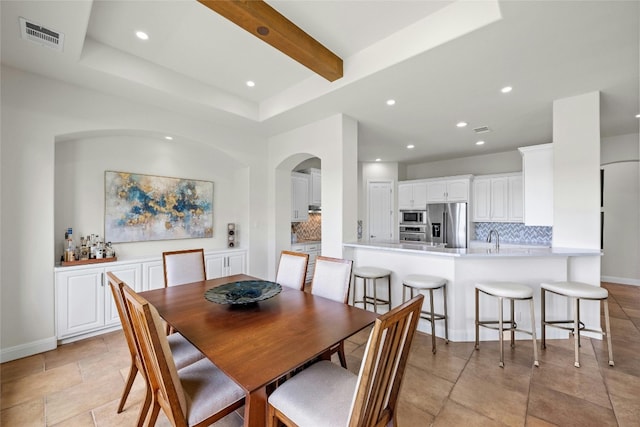 dining room with a tray ceiling, beam ceiling, recessed lighting, visible vents, and baseboards