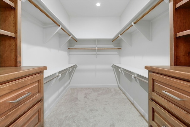 walk in closet featuring light colored carpet