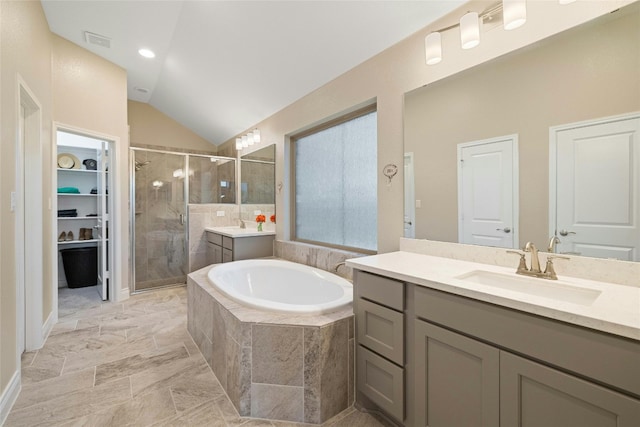 bathroom with vanity, vaulted ceiling, and independent shower and bath