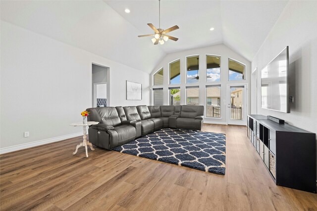 living room with ceiling fan, hardwood / wood-style floors, and high vaulted ceiling