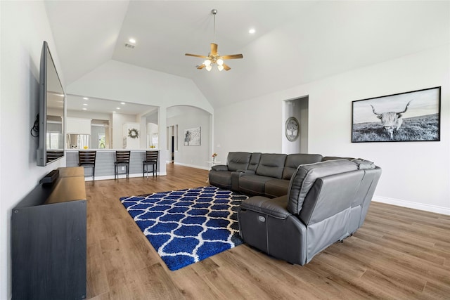 living room with lofted ceiling, hardwood / wood-style floors, and ceiling fan