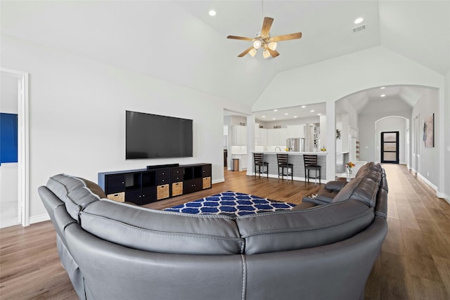 living room with high vaulted ceiling, hardwood / wood-style floors, and ceiling fan