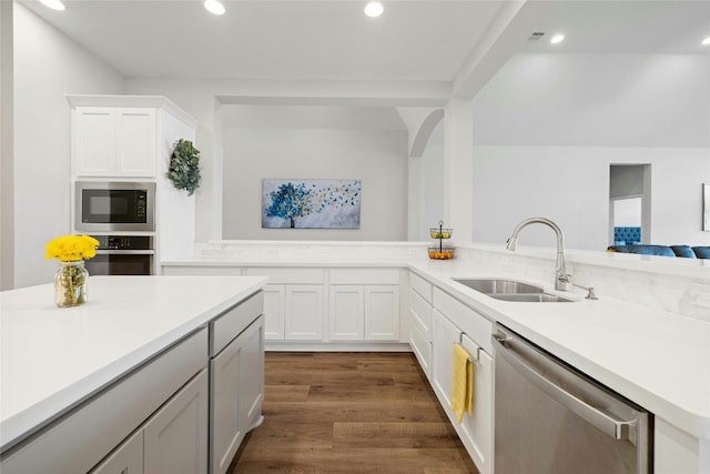 kitchen with white cabinetry, stainless steel appliances, dark wood-type flooring, and sink