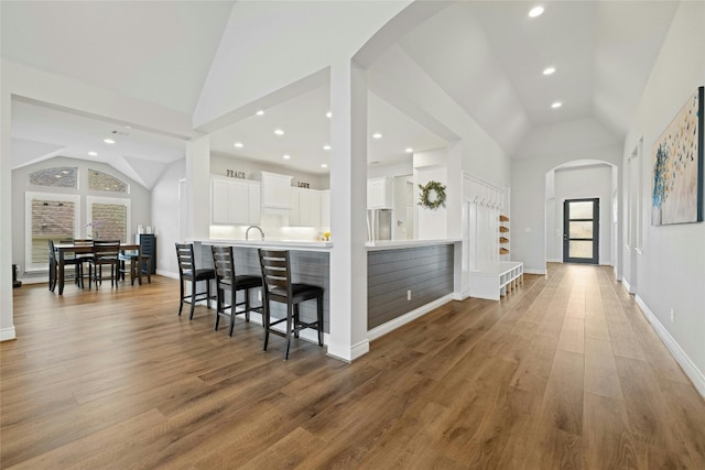 kitchen featuring white cabinetry, hardwood / wood-style floors, plenty of natural light, and a breakfast bar