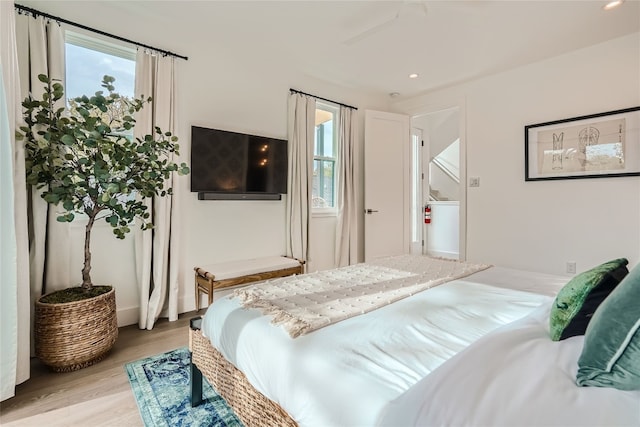 bedroom featuring multiple windows, ceiling fan, and light hardwood / wood-style floors