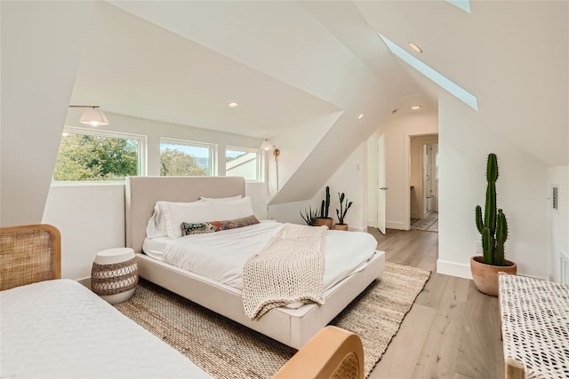 bedroom featuring light wood-type flooring and lofted ceiling