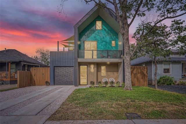 contemporary home featuring a balcony and a lawn