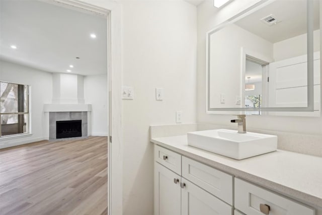 bathroom featuring a fireplace, wood-type flooring, and vanity