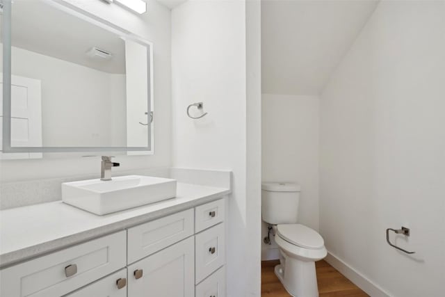 bathroom with hardwood / wood-style flooring, vanity, and toilet