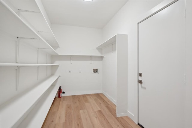 laundry area with gas dryer hookup, hookup for a washing machine, and light hardwood / wood-style floors