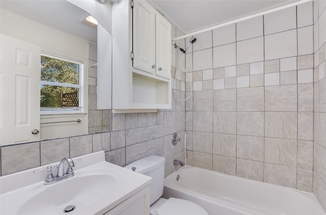 full bathroom featuring vanity, decorative backsplash, tiled shower / bath combo, toilet, and tile walls