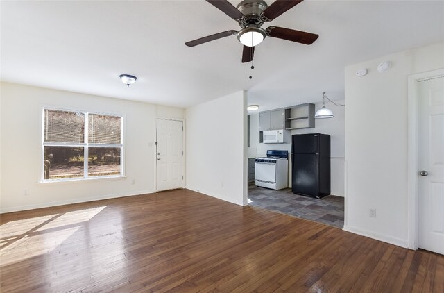 unfurnished living room with ceiling fan and dark wood-type flooring