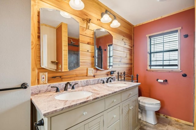 bathroom with vanity, toilet, and wooden walls