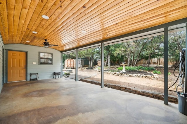 unfurnished sunroom featuring ceiling fan, plenty of natural light, wood ceiling, and vaulted ceiling