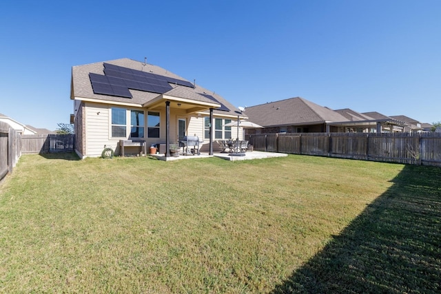 rear view of property featuring solar panels, a patio area, and a yard