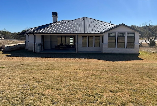 rear view of property with a lawn and a patio area