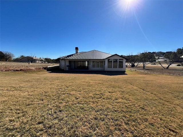 back of house with a yard and a rural view