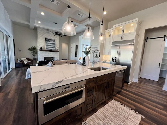 kitchen with coffered ceiling, sink, white cabinets, and beamed ceiling