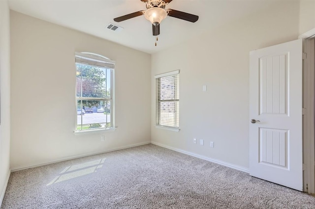 empty room featuring carpet floors, a wealth of natural light, and ceiling fan