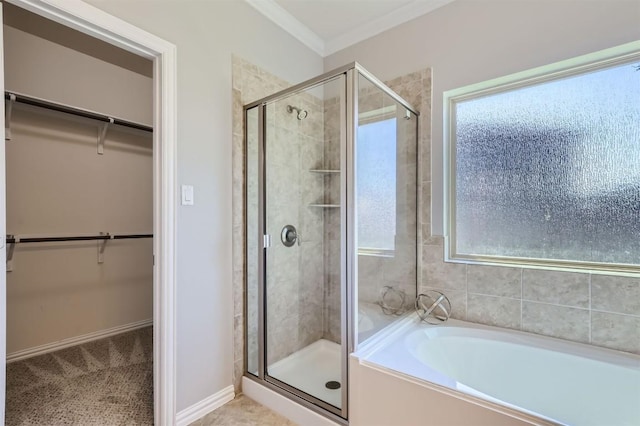 bathroom with ornamental molding and shower with separate bathtub