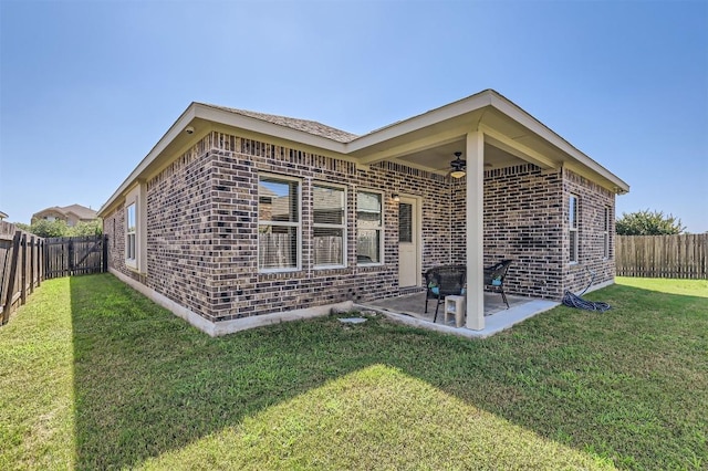 back of property with a patio area and a lawn