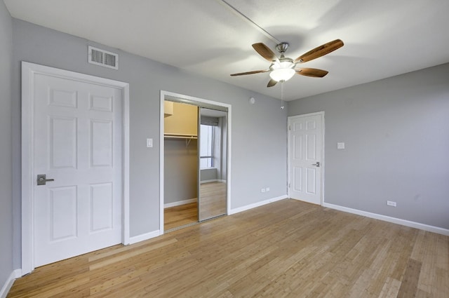 unfurnished bedroom with ceiling fan, light hardwood / wood-style floors, and a walk in closet