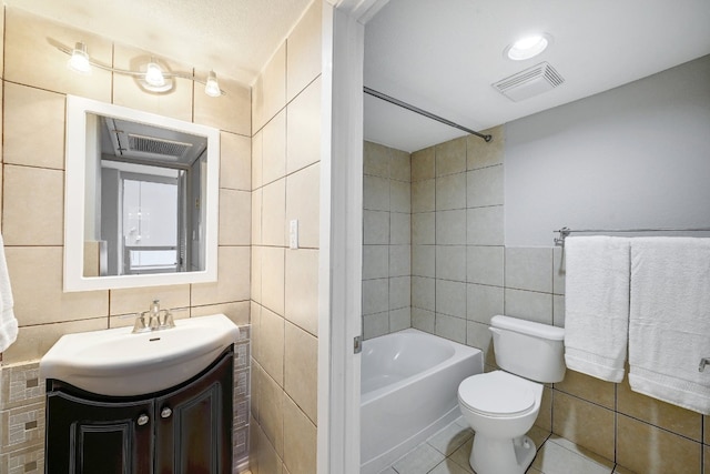 full bathroom featuring tile patterned floors, toilet, tile walls, shower / washtub combination, and vanity