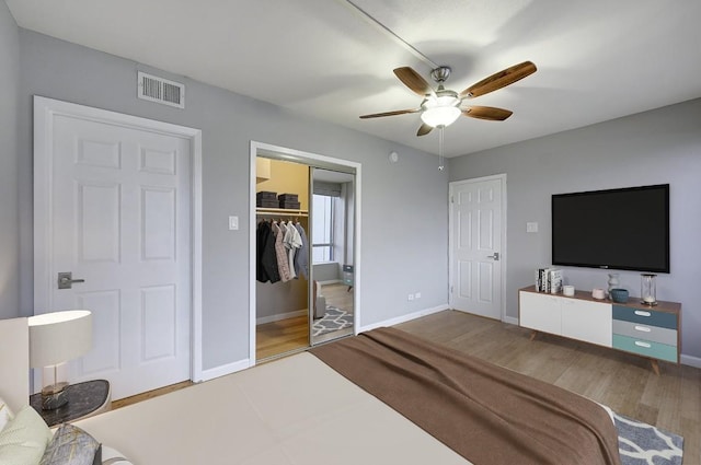 bedroom with ceiling fan, connected bathroom, and hardwood / wood-style floors